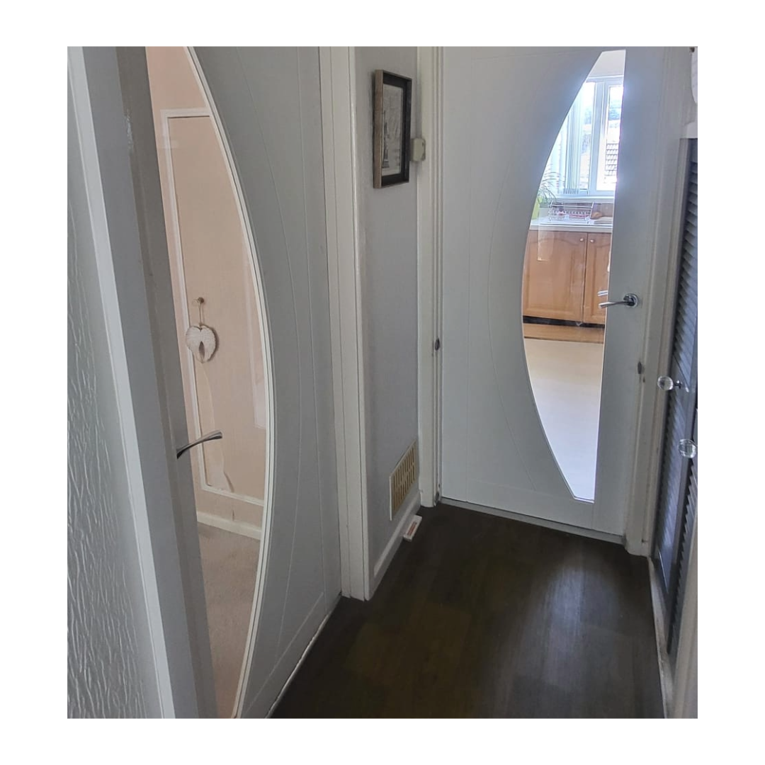 Two internal white doors in a hallway with a semi-circle of glass in the doors.